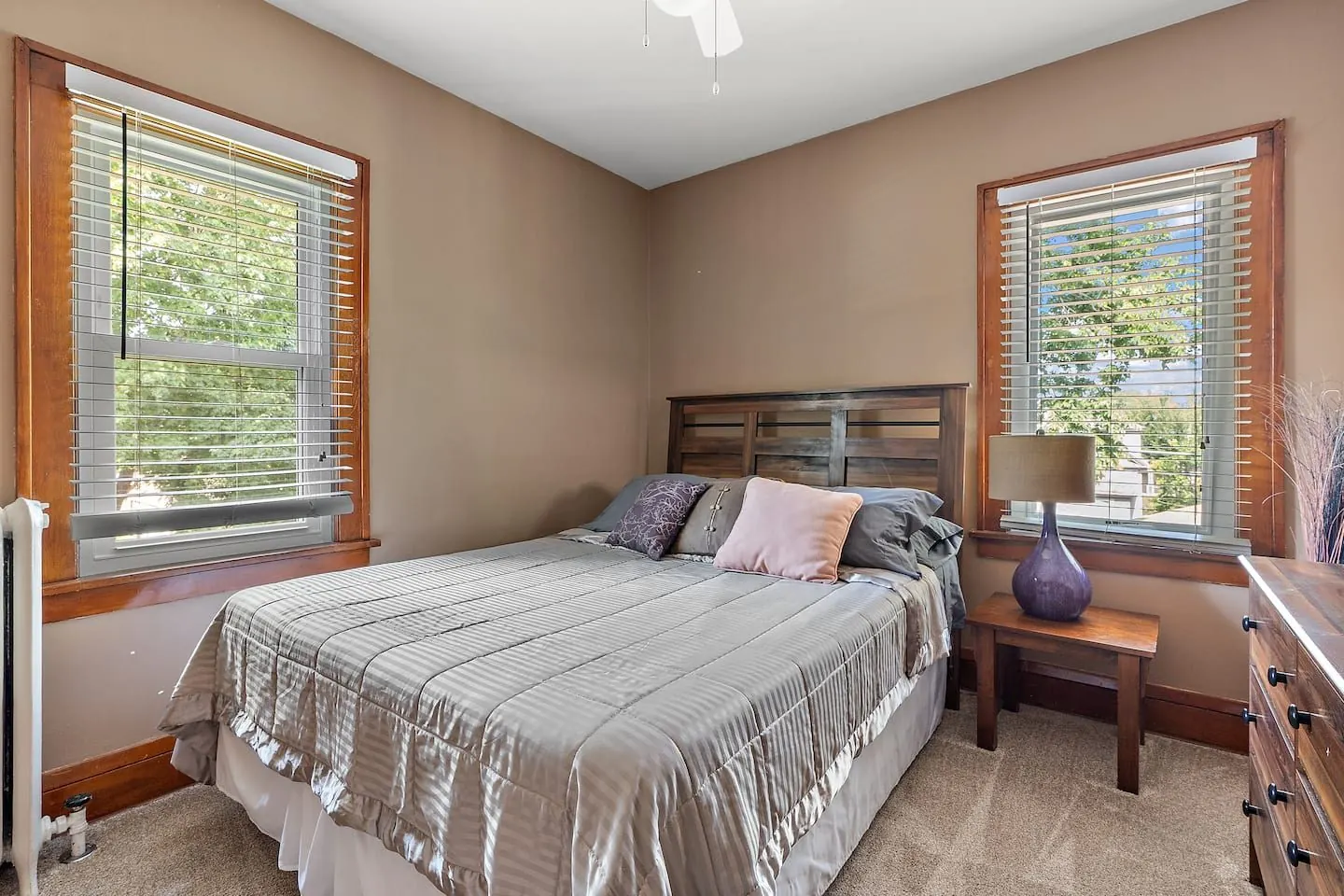 Primary bedroom with a queen bed and two windows